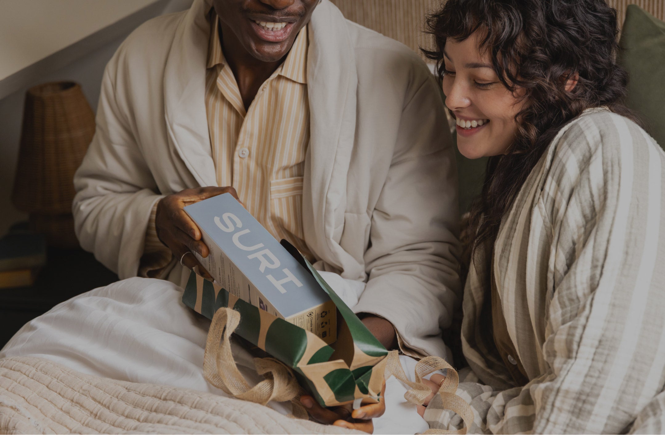 Two people smiling while holding a SURI box together.